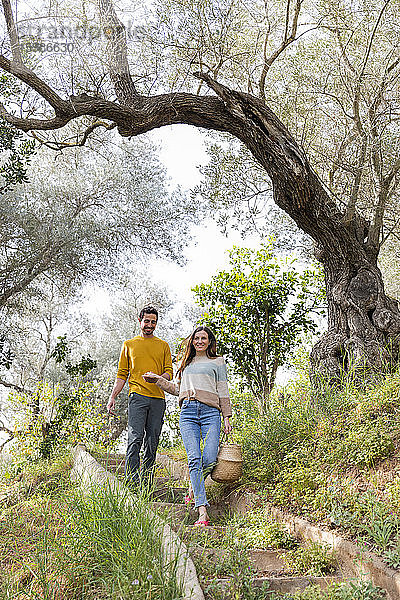 Glückliches Paar  das auf einer Treppe inmitten von Pflanzen auf dem Lande spazieren geht