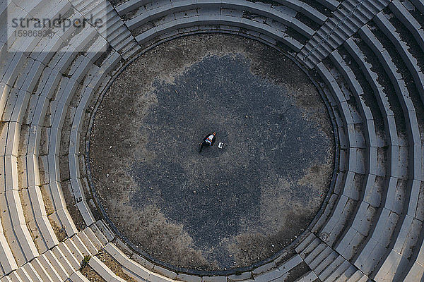 Geschäftsmann liegt im Amphitheater der BergArena