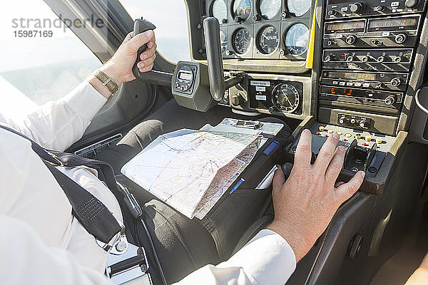 Pilot fliegt im Sportflugzeug  VFR-Karte auf dem Schoß