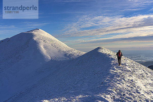 Italien  Provinz Pesaro und Urbino  Männlicher Wanderer auf dem schneebedeckten Gipfel des Monte Acuto