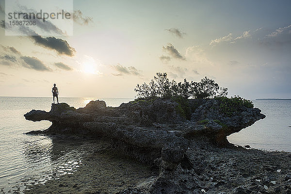 Mann auf einem Felsen an der Meeresküste in Ouvea  Loyalitätsinseln  Neukaledonien
