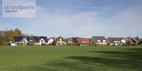 Deutschland  Nordrhein-Westfalen  Kamen  Panorama einer grünen Wiese vor ländlichen Häusern