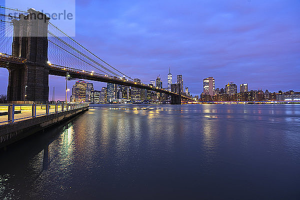 USA  New York  New York City  East River und Brooklyn Bridge in der lila Morgendämmerung mit der Skyline von Manhattan im Hintergrund