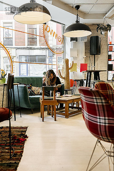 Frau liest ein Buch in einem Café