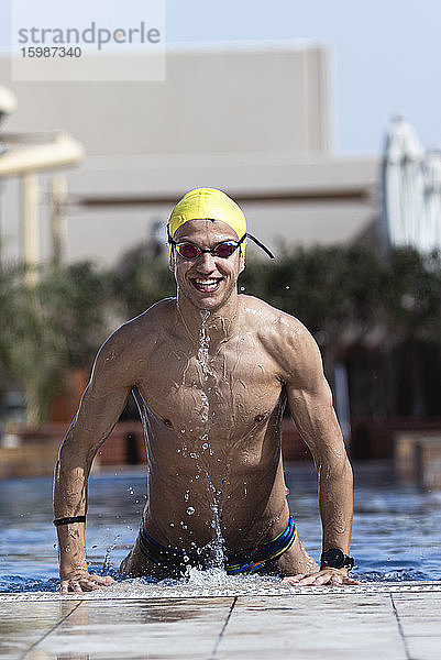 Glücklicher Schwimmer  der aus dem Pool in einer Ferienanlage kommt  Dubai  Vereinigte Arabische Emirate