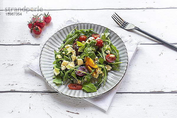 Teller mit vegetarischem Low-Carb-Salat mit Rucola  Tomaten  Nüssen und Mozzarella