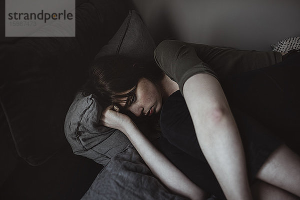 Depressive junge Frau im Bett liegend