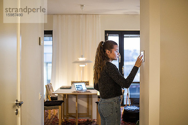 Teenager-Mädchen mit digitalem Tablett an der Wand zu Hause