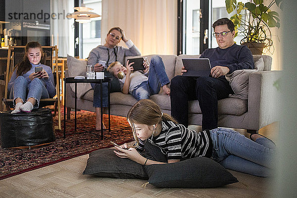 Familie nutzt Technologien im Wohnzimmer im modernen Zuhause