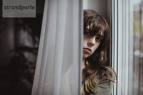 Porträt einer Frau am Fenstervorhang