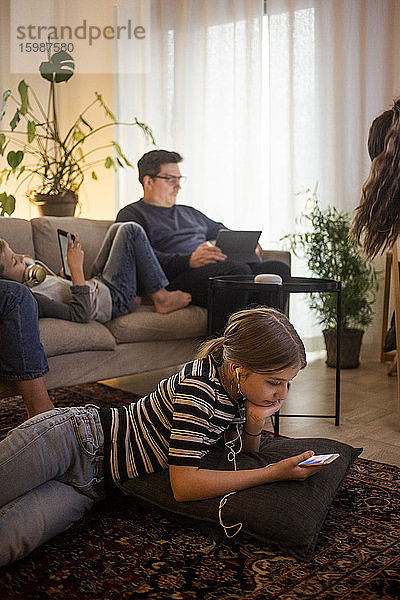Familie nutzt Technologien im Wohnzimmer im Smart Home