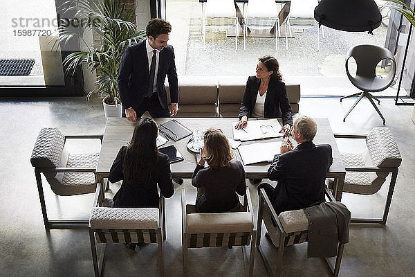 Hoher Blickwinkel der Finanzberater mit dem Geschäftsmann und der Geschäftsfrau  die während des Treffens im Amt planen