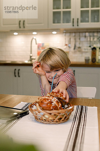 Junge mit Dessert auf dem Esstisch zu Hause