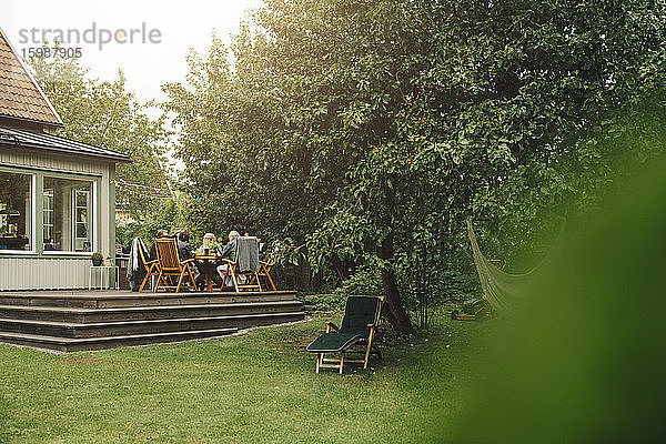 Ältere Männer und Frauen  die während einer Gartenparty am Esstisch sitzen