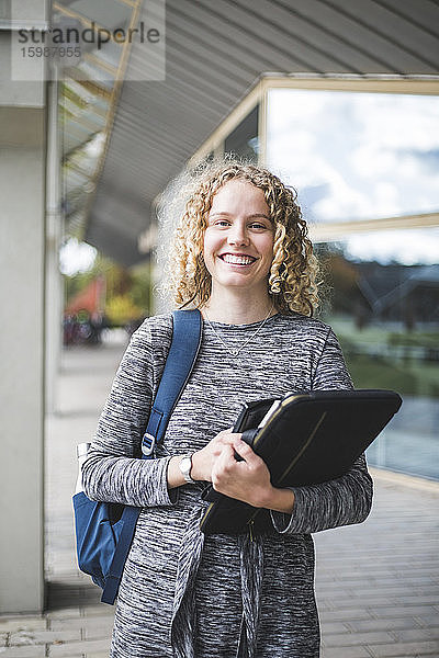 Porträt einer lächelnden jungen Frau an der Universität