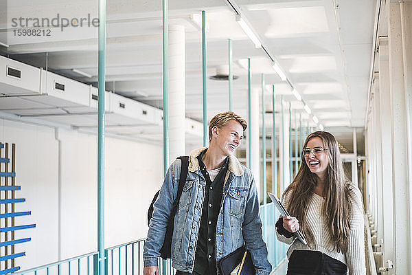 Glückliche männliche und weibliche Studenten auf dem Korridor der Universität