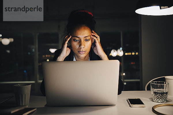 Junge Unternehmerin mit Kopfschmerzen bei späterer Arbeit im Büro