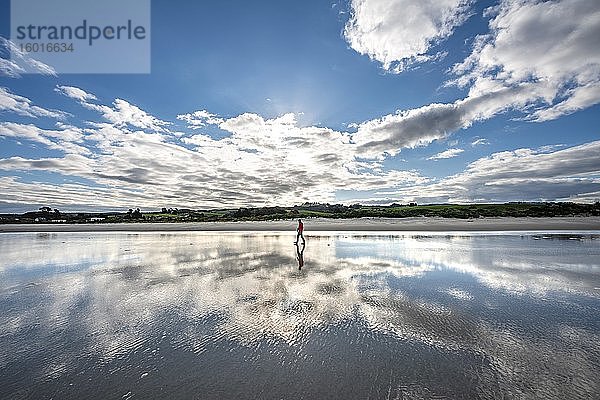 Spiegelung  junger Mann läuft am weiten Sandstrand bei Ebbe  Taieri Beach  Südinsel  Neuseeland  Ozeanien