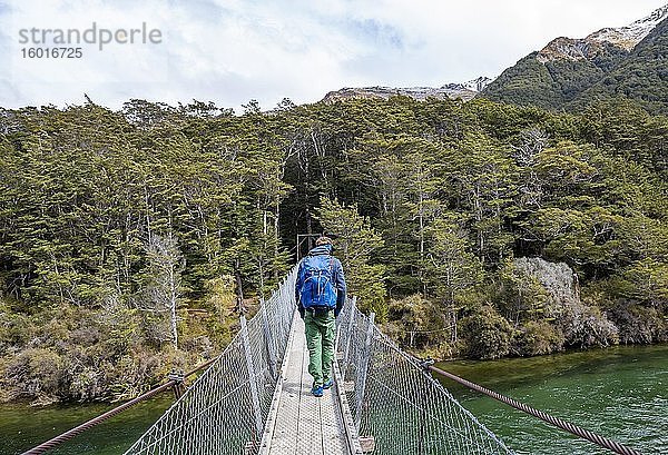 Junger Mann auf einer Hängebrücke über den Mavora River  Mavora  Southland  Südinsel  Neuseeland  Ozeanien