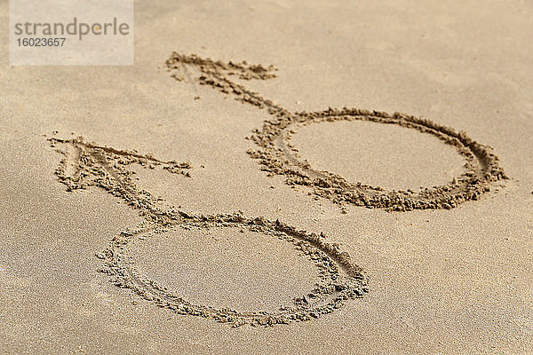 Männliche Geschlechtssymbole auf Sandstrand geschrieben