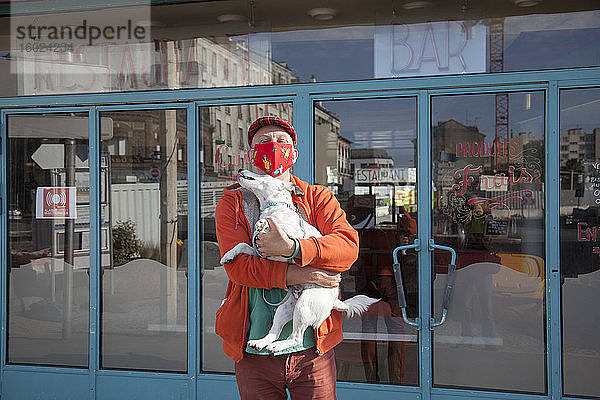 Mann mit Hund und Coronavirus-Schutzmaske