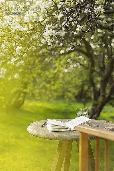 Offene Zeitschrift auf dem Tisch im sonnigen idyllischen Garten