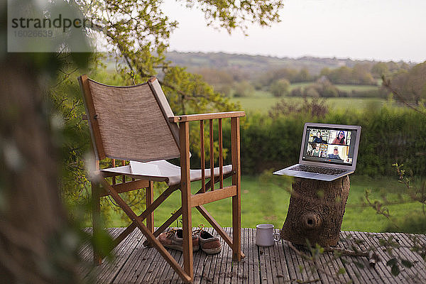 Video-Chat mit Kollegen auf dem Laptop-Bildschirm auf dem ländlichen Balkon