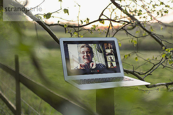 Video-Chat mit Freunden auf Laptop-Bildschirm am ländlichen Zaunpfahl