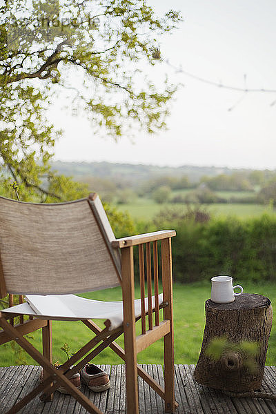 Buch und Stuhl auf dem Balkon mit Blick auf das ländliche Feld