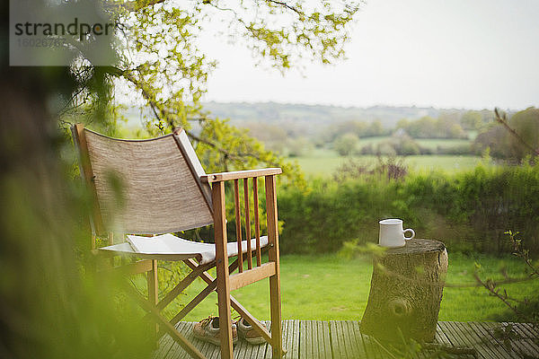 Stuhl und Kaffee auf ruhigem Balkon mit Blick auf das ländliche Feld