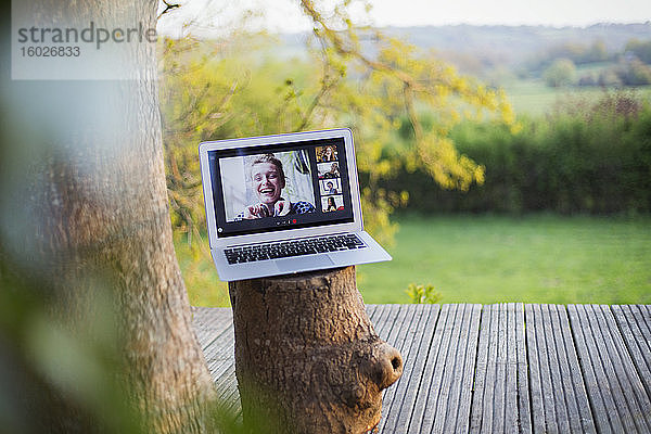 Video-Chat mit Freunden am Laptop-Bildschirm auf dem idyllischen Balkon