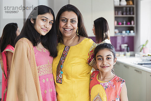 Porträt glückliche indische Mutter und Töchter in Saris