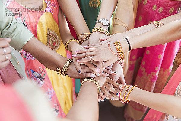 Indische Frauen in Armbändern reichen sich die Hände