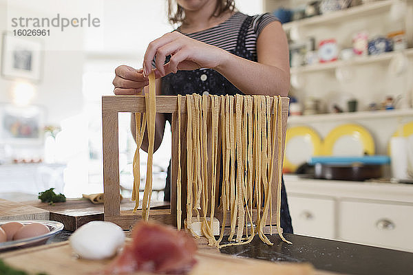 Teenager-Mädchen macht in der Küche frische hausgemachte Pasta