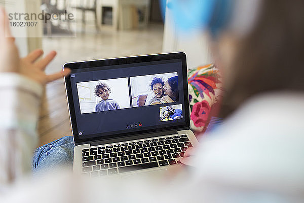 Frau im Video-Chat mit Familie auf Laptop-Bildschirm