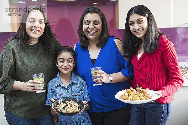 Porträt glücklicher indischer Frauen und Mädchen beim Kochen in der Küche