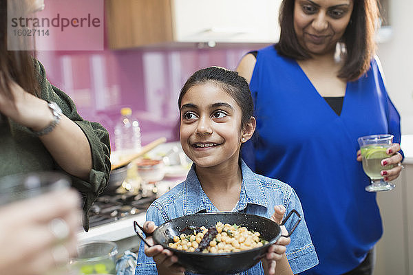 Glückliches indisches Mädchen mit Futterschüssel in der Küche