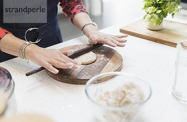 Nahaufnahme einer Inderin  die in der Küche Naan-Brot backt