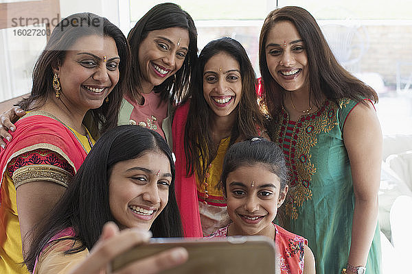 Glückliche indische Frauen und Mädchen in Saris beim Selfie mit dem Smartphone