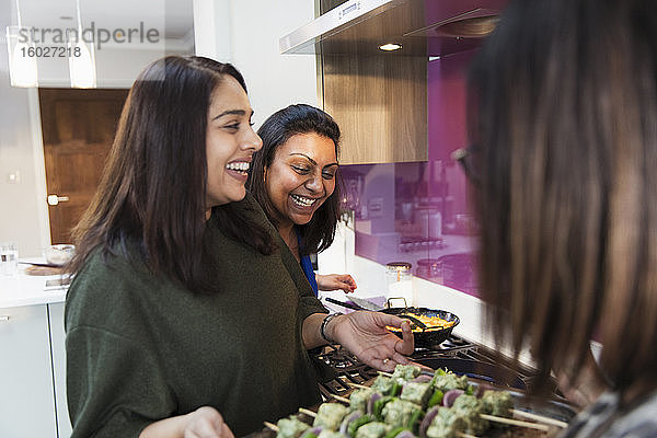 Glückliche indische Frauen  die in der Küche Essen zubereiten