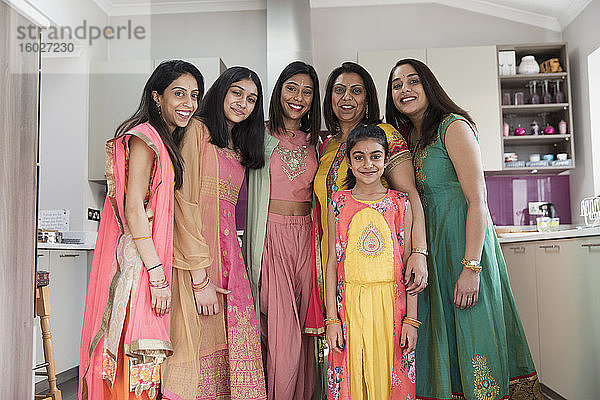 Porträt glücklicher indischer Frauen und Mädchen in Saris in der Küche
