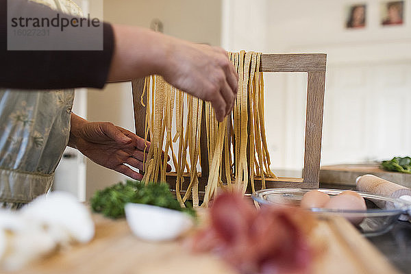 Frau macht in der Küche frische hausgemachte Pasta