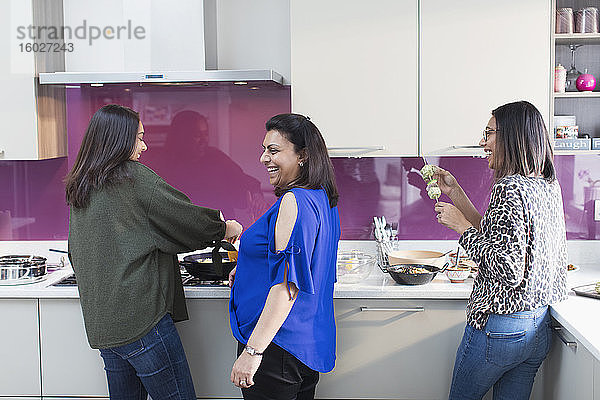 Glückliche indische Frauen kochen Essen in der Küche