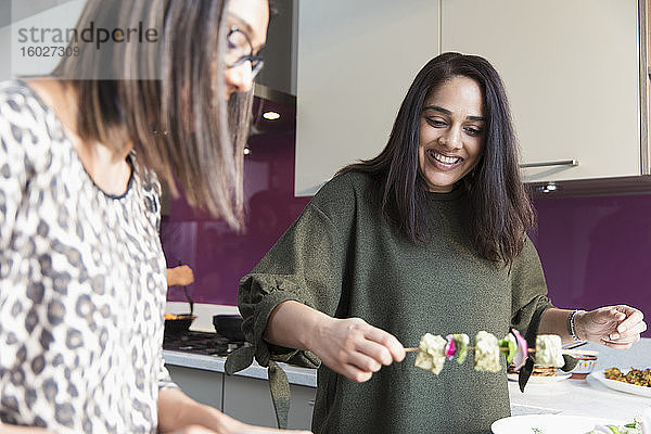 Indische Frauen bereiten in der Küche Essensspießchen zu