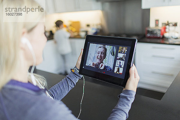 Frau im Video-Chat mit Freunden auf digitalem Tablet