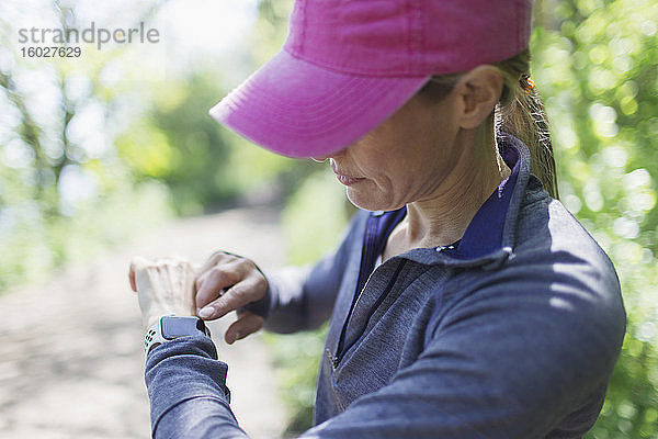 Joggerin mit smarter Uhr auf Wanderweg