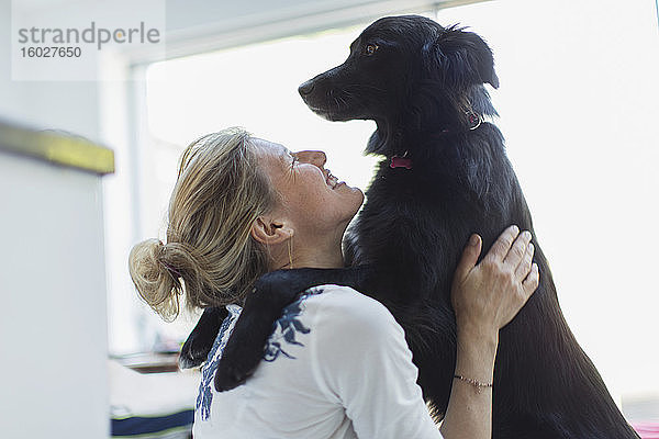 Glückliche Frau umarmt Hund