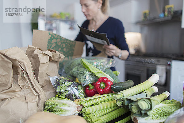 Frau beim Entladen frischer Produkte aus dem Karton in der Küche