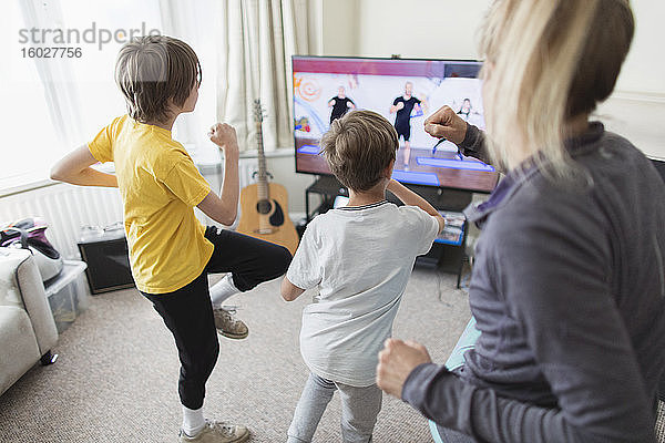 Familie übt am Fernseher im Wohnzimmer