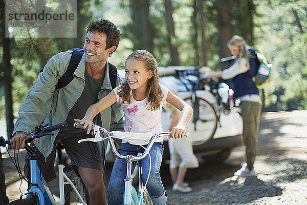 Vater und Tochter auf Fahrrädern im Wald